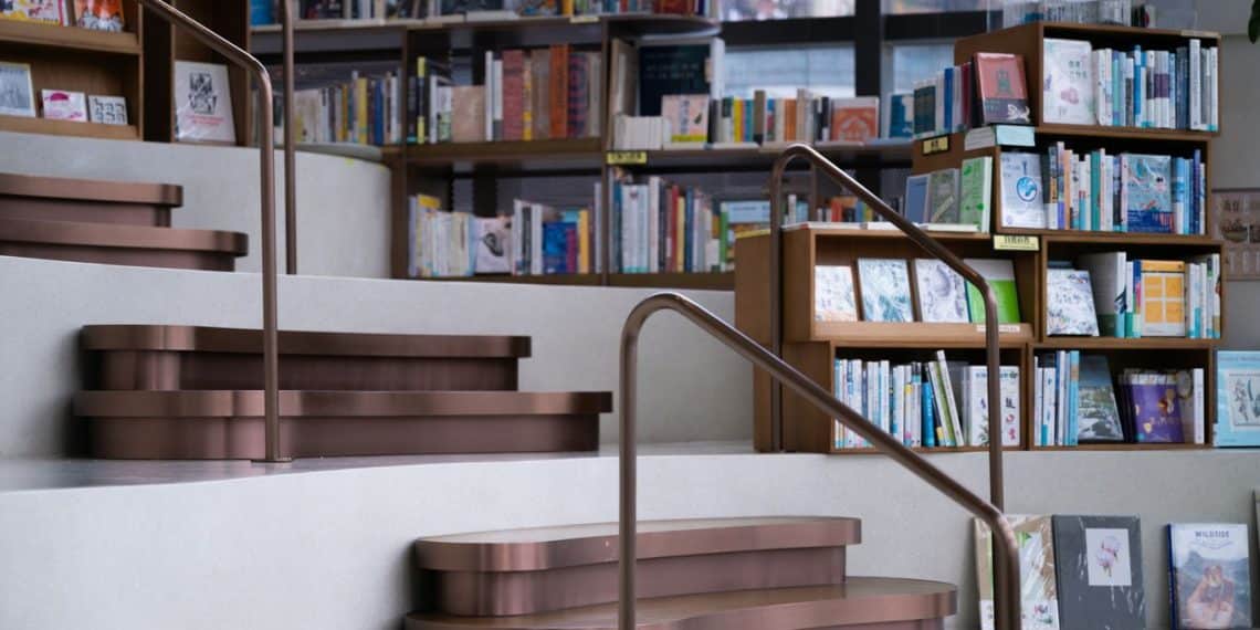 a set of stairs leading up to a bookshelf filled with books