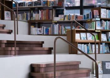 a set of stairs leading up to a bookshelf filled with books